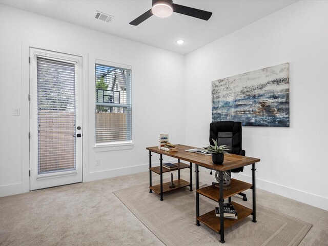 carpeted home office featuring ceiling fan