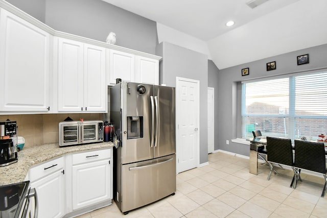 kitchen with white cabinets, stainless steel refrigerator with ice dispenser, decorative backsplash, and range