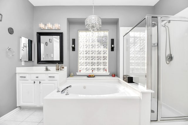 bathroom with tile patterned floors, vanity, an inviting chandelier, and separate shower and tub