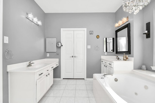 bathroom featuring tile patterned floors, vanity, tiled tub, and an inviting chandelier