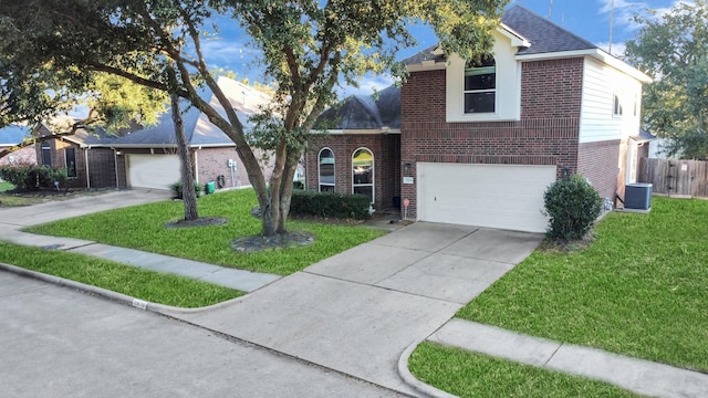 view of front of house with a front lawn, a garage, and central AC unit