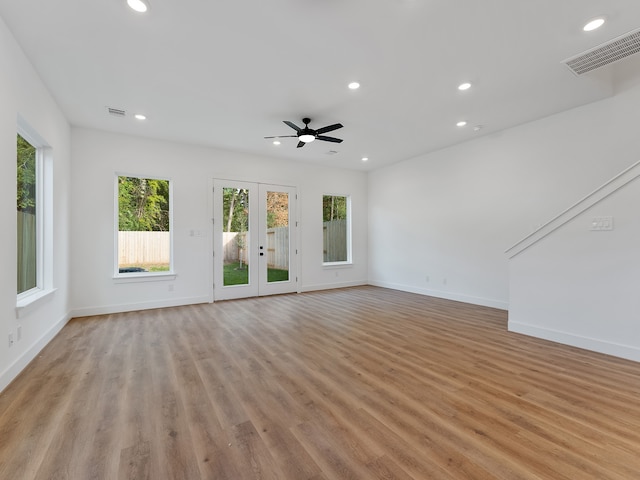 unfurnished living room featuring ceiling fan, french doors, and light wood-type flooring