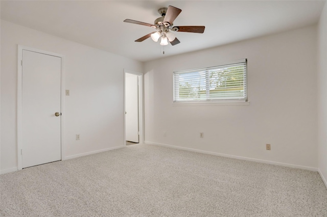 carpeted empty room featuring ceiling fan