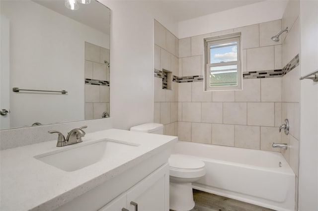 full bathroom with wood-type flooring, vanity, toilet, and tiled shower / bath combo