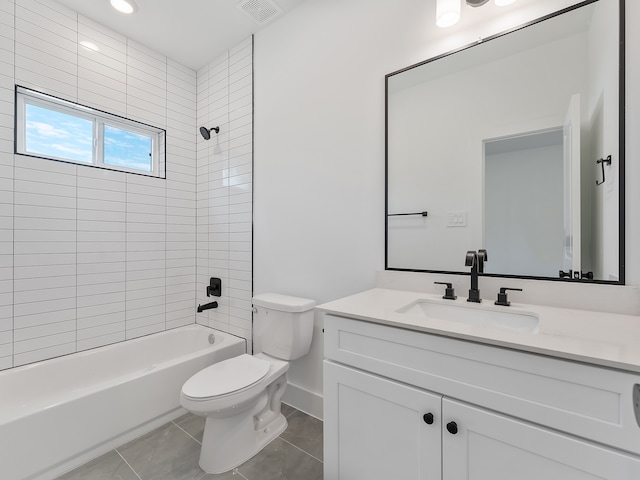 full bathroom with tile patterned floors, vanity, tiled shower / bath combo, and toilet