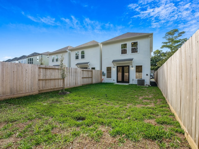 rear view of property with a lawn and cooling unit