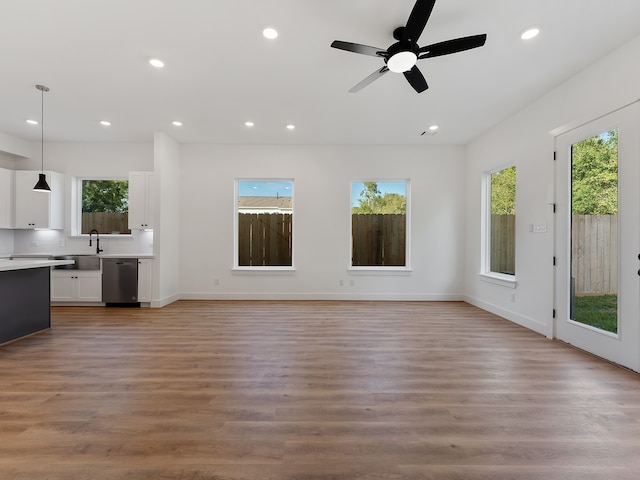 unfurnished living room with ceiling fan, light hardwood / wood-style flooring, and sink