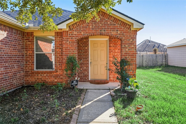 entrance to property featuring a lawn