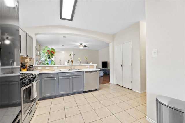 kitchen featuring stainless steel appliances, ceiling fan, sink, light tile patterned floors, and gray cabinets