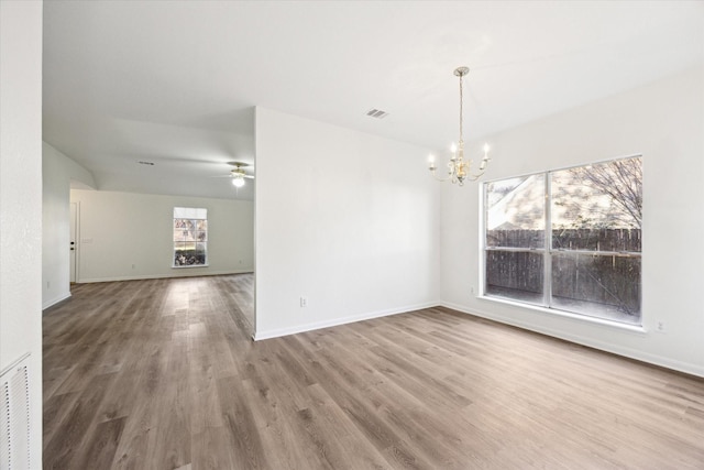 interior space with hardwood / wood-style floors and ceiling fan with notable chandelier