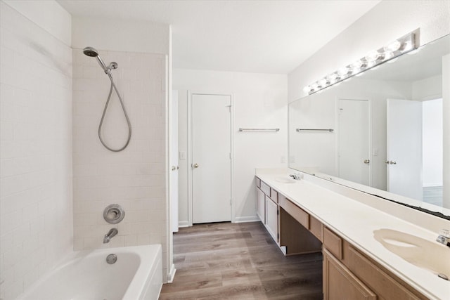 bathroom featuring vanity, wood-type flooring, and tiled shower / bath