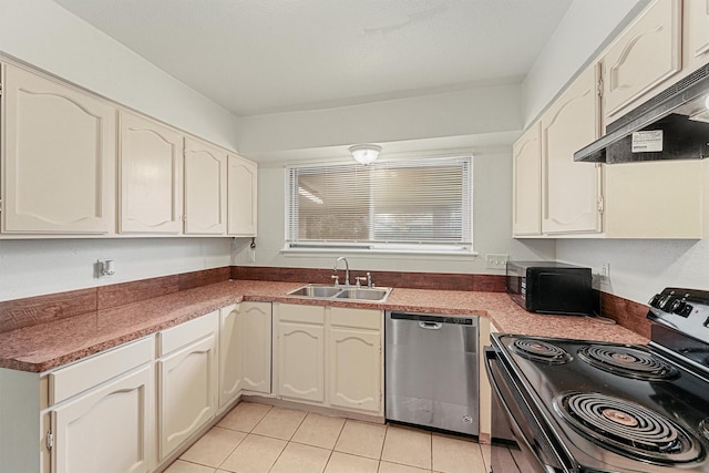 kitchen featuring appliances with stainless steel finishes, sink, light tile patterned floors, and white cabinets