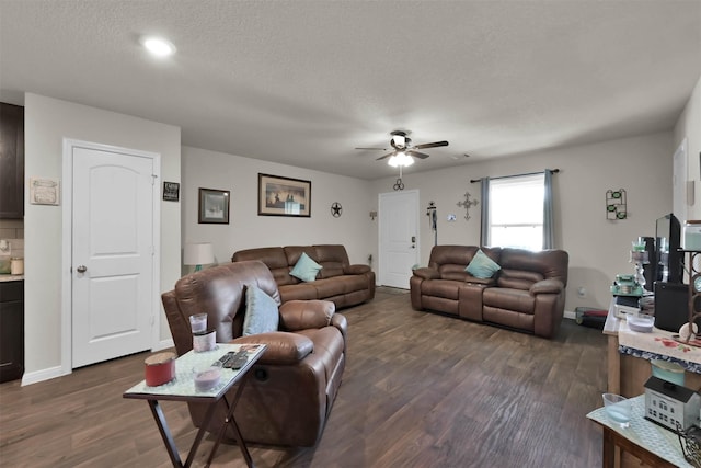 living room featuring a textured ceiling, ceiling fan, and dark wood-type flooring