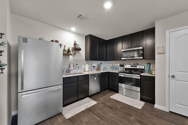 kitchen featuring stainless steel appliances, dark hardwood / wood-style flooring, sink, and backsplash