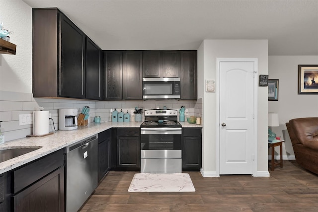 kitchen with backsplash, stainless steel appliances, and dark wood-type flooring