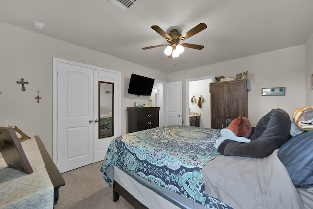 carpeted bedroom featuring ceiling fan, a closet, and ensuite bathroom