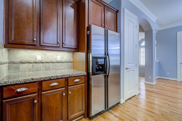 kitchen featuring light stone countertops, tasteful backsplash, light hardwood / wood-style flooring, stainless steel refrigerator with ice dispenser, and ornamental molding