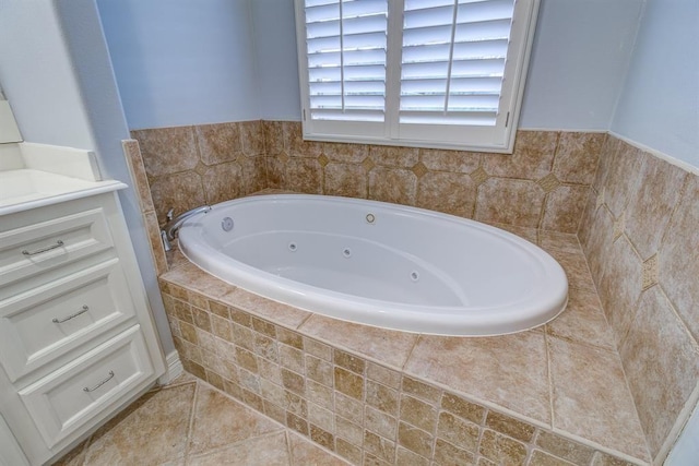 bathroom with tile patterned floors, a relaxing tiled tub, and vanity