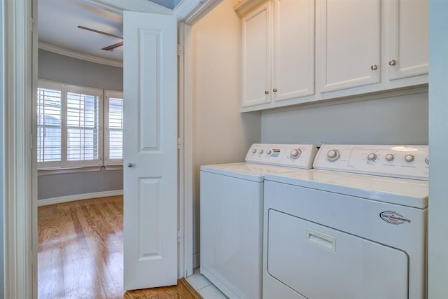 clothes washing area with light hardwood / wood-style floors, washer and dryer, cabinets, and ornamental molding