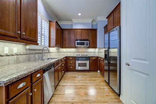 kitchen with light stone countertops, appliances with stainless steel finishes, tasteful backsplash, and sink