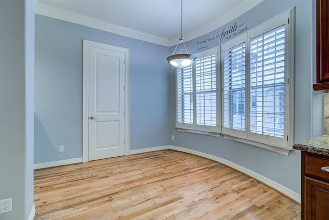 unfurnished dining area featuring plenty of natural light, ornamental molding, and light wood-type flooring