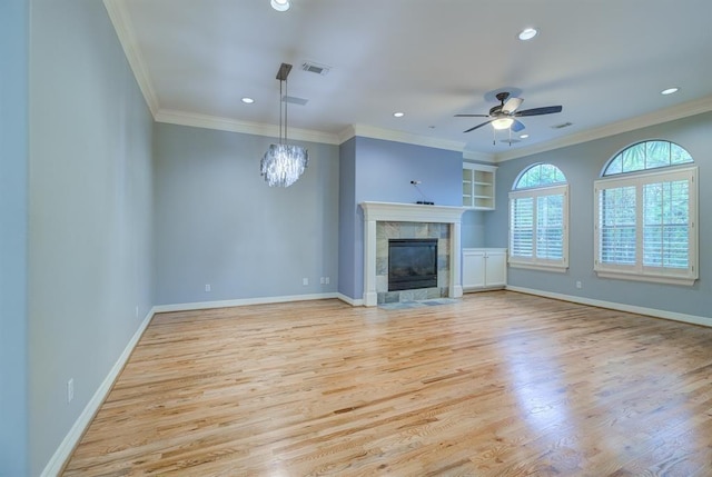 unfurnished living room with ceiling fan with notable chandelier, light hardwood / wood-style floors, and crown molding