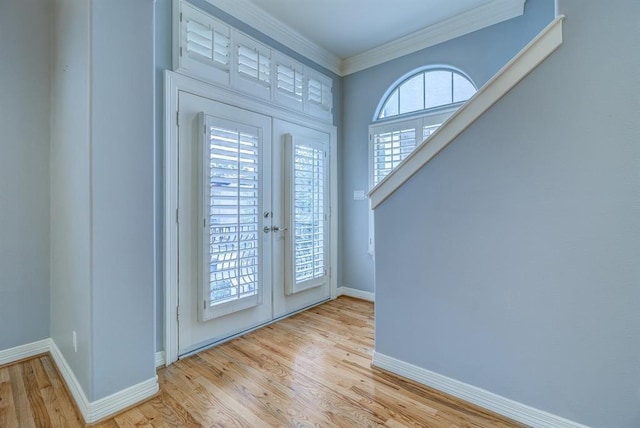 foyer featuring french doors, light hardwood / wood-style flooring, and crown molding