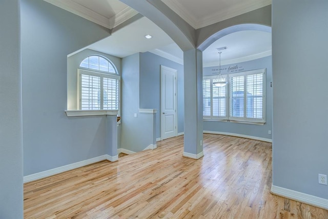 empty room featuring light wood-type flooring and crown molding