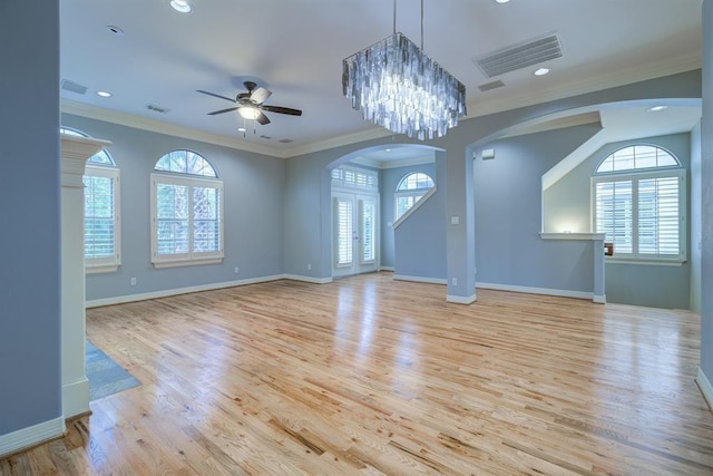 unfurnished living room with crown molding, light hardwood / wood-style floors, and ceiling fan with notable chandelier