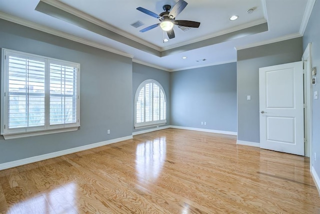 unfurnished room featuring a raised ceiling, plenty of natural light, and ornamental molding