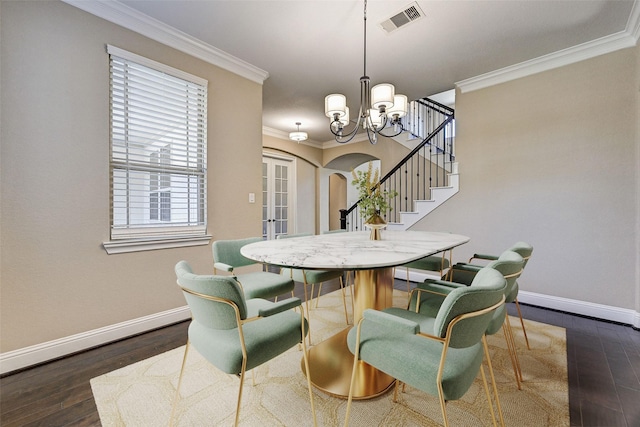 dining room featuring dark hardwood / wood-style flooring, crown molding, and a chandelier