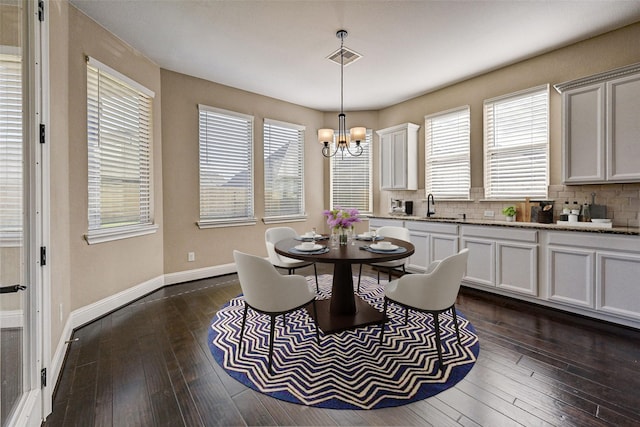 dining area featuring dark hardwood / wood-style flooring, a chandelier, and sink