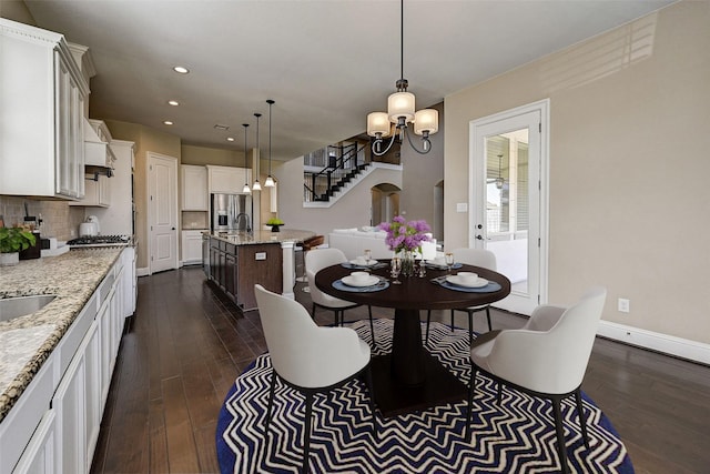 dining room featuring dark hardwood / wood-style flooring, an inviting chandelier, and sink