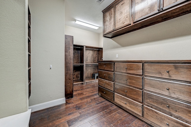 walk in closet with dark wood-type flooring