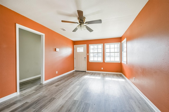 unfurnished room with ceiling fan and light wood-type flooring