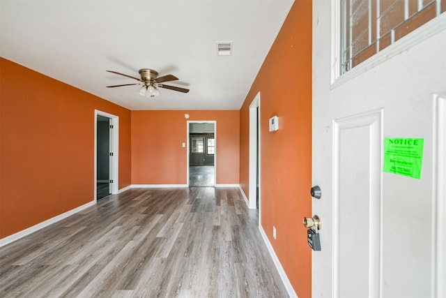 empty room with ceiling fan and light hardwood / wood-style flooring