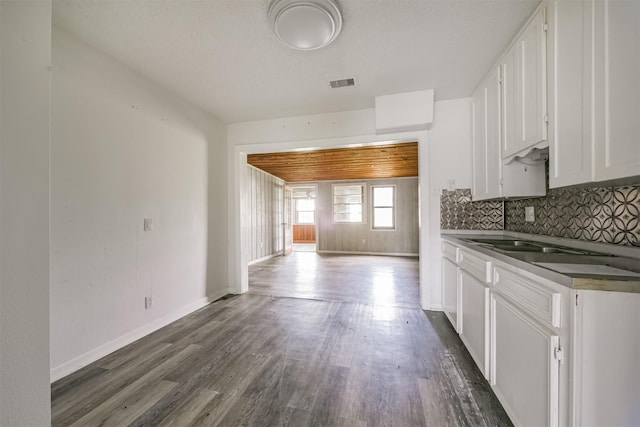 kitchen with white cabinets, decorative backsplash, dark hardwood / wood-style floors, and wooden ceiling