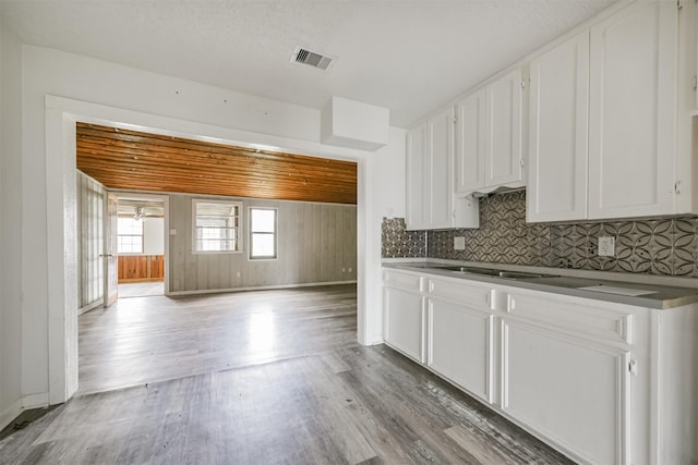 kitchen featuring tasteful backsplash, white cabinetry, light hardwood / wood-style flooring, and wood ceiling