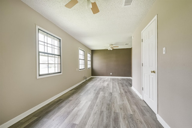 unfurnished room with ceiling fan, light hardwood / wood-style floors, and a textured ceiling