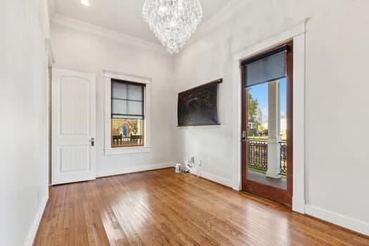 1148 Nicholson St, Houston, TX 77008 - unfurnished room with crown molding, baseboards, wood finished floors, and a chandelier