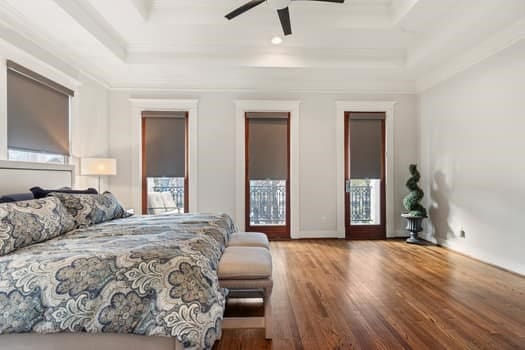 1148 Nicholson St, Houston, TX 77008 - bedroom with ceiling fan, crown molding, wood finished floors, baseboards, and a tray ceiling