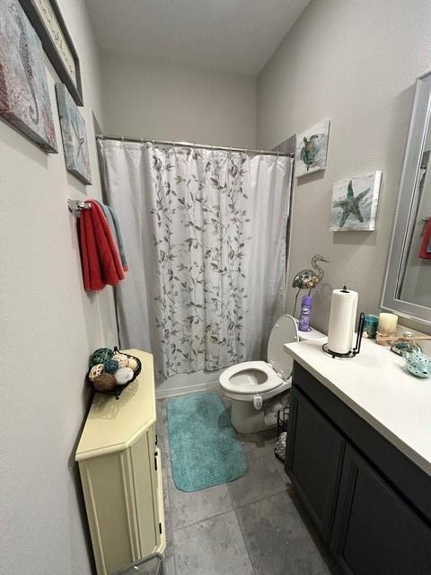 full bathroom with toilet, vanity, tile patterned floors, and shower / tub combo with curtain