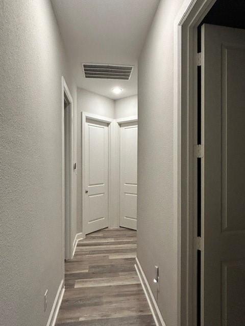 corridor with hardwood / wood-style floors