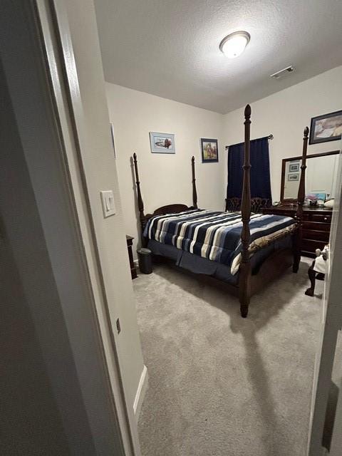 carpeted bedroom with a textured ceiling