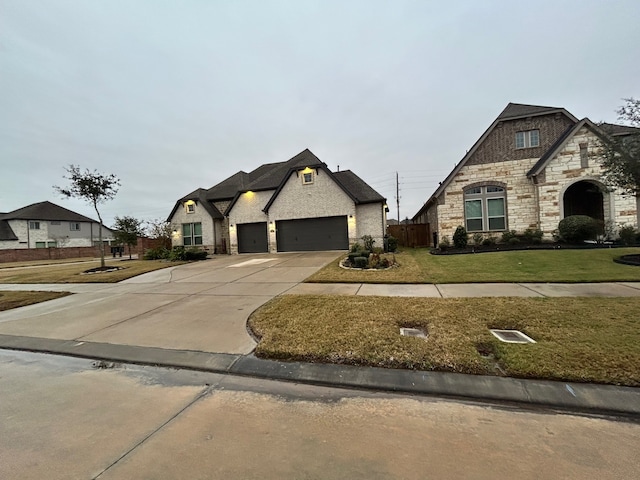 french country style house with a front yard and a garage