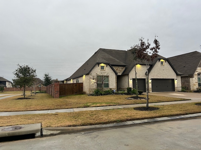 french country home featuring a front yard and a garage