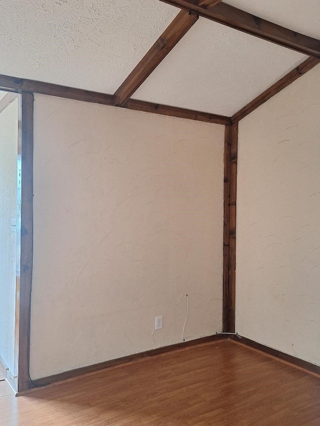 unfurnished room with hardwood / wood-style flooring and a textured ceiling