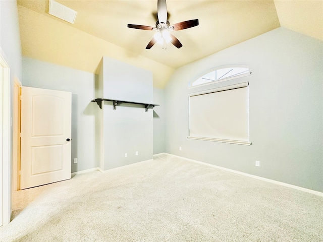 spare room featuring ceiling fan, light colored carpet, and vaulted ceiling