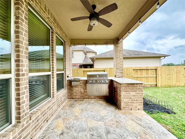 view of patio with grilling area, ceiling fan, and exterior kitchen