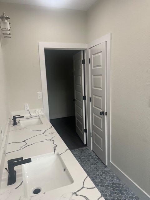 bathroom featuring a sink and baseboards